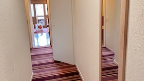 A narrow hallway with striped carpet leading to a door. - Comfortable 2-room apartment with panoramic view in Avoriaz (Avoriaz)