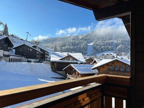A snowy village with wooden buildings and a ski lift in the background.