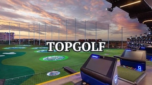 A golf course with multiple tee boxes, a netted area, and a scoreboard. - Dazzle-In Old Town-Walk to Entertainment District (Scottsdale)