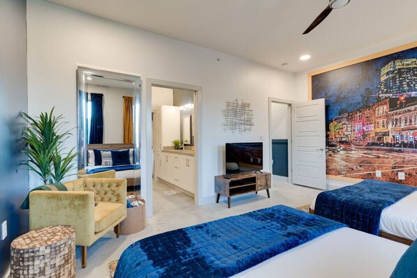 A modern hotel room with a bed, a TV, a desk, and a large window.