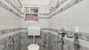 A compact bathroom with a toilet, shower, and sink. - zion backpackers hostel (Guwahati)