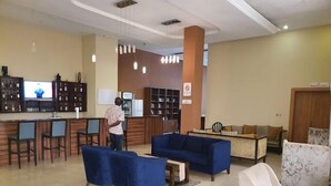 A hotel lobby with a bar area, seating arrangements, and a television screen. - BON Hotel  (Ado Ekiti)