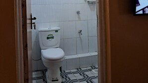 A bathroom with a toilet, a shower, and a tiled floor. - Superhighway Haven, 2 Mins To SpurMall Kimbo-Ruiru,  EXIT 12&13 Thika Road (Kimbo, Ruiru)