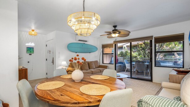 A modern dining area with a wooden table, woven placemats, and a decorative vase.
