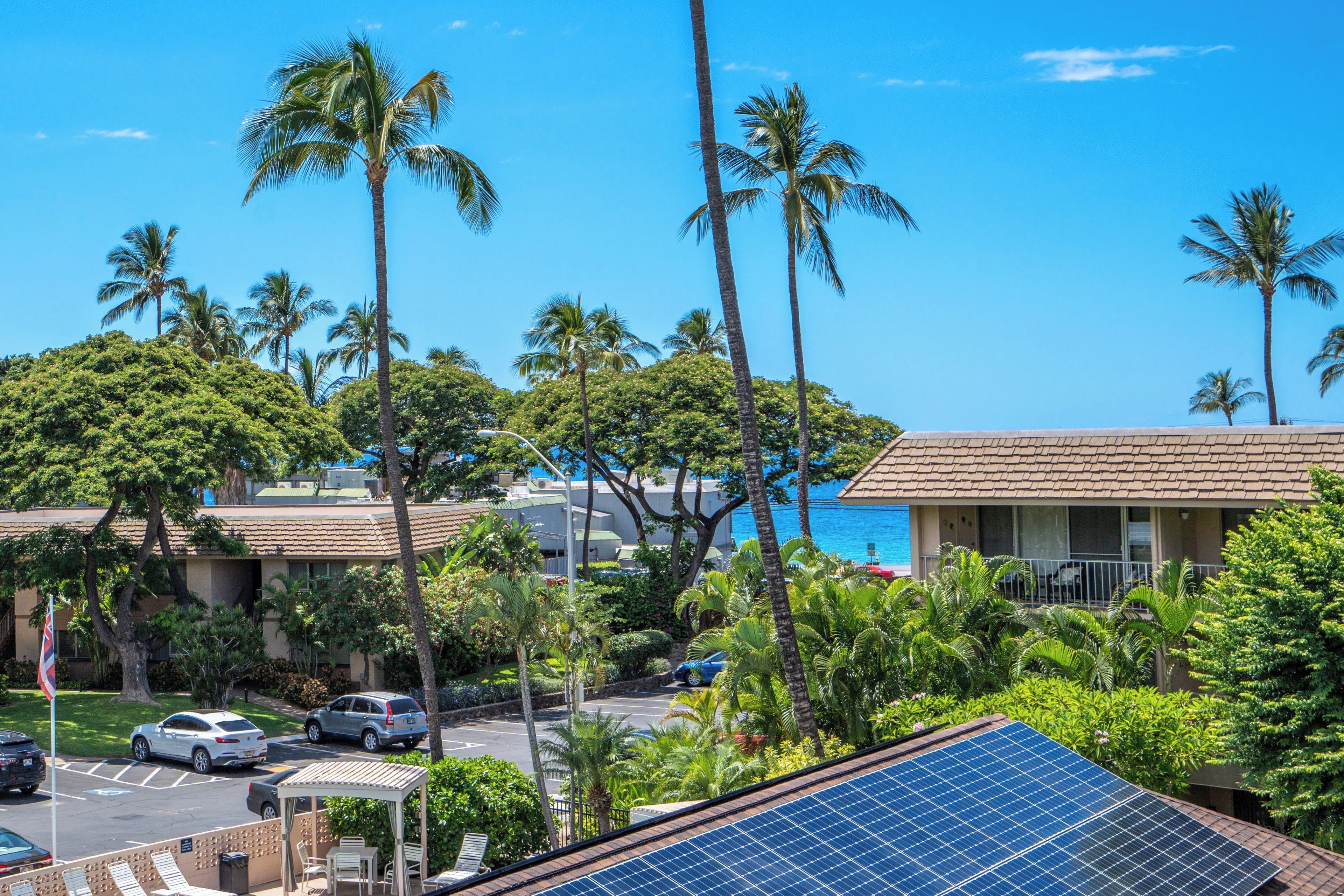 Ein Hotel mit Pool, Palmen und Solaranlage.
