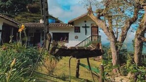 A white house with a cross on the wall, surrounded by greenery and trees. - Beauty farm, only 25 minutes away from Cali (Cali)