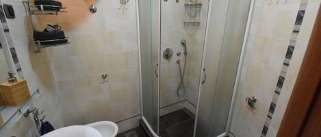 A modern bathroom with a glass-enclosed shower, a white sink, and a toilet.