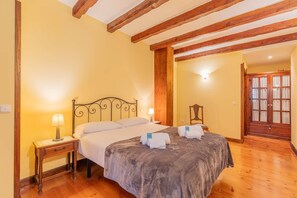 A bedroom with a bed, bedside tables, and a wooden ceiling.