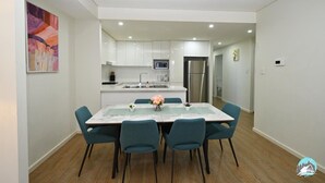 A modern kitchen with white cabinets, a stainless steel refrigerator, and a microwave. - Comfortable 2 Bed Apartment in Canterbury (Canterbury)
