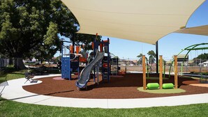 A playground with a slide, climbing structures, and a shaded area. - Comfortable 2 Bed Apartment in Canterbury (Canterbury)