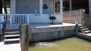 Un muelle con una escalera de madera que conduce a una plataforma de hormigón.