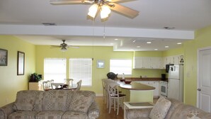 A living room with a sofa, a coffee table, and a ceiling fan. - Pelican Point #4 - Great Complex! Great Views! Cool off in the swimming pool! (Port Mansfield)