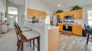 A spacious kitchen with wooden cabinets, a central island, and modern appliances. - 15 Mi to Universal: Home w/ Pool (Kissimmee)