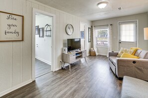 A living room with a television, sofa, and a wall with a framed quote. - Walk to Dtwn Branson: Pet-friendly Home! (Branson)