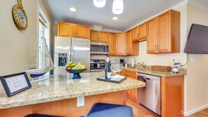 A modern kitchen with wooden cabinets, granite countertops, stainless steel appliances, and a built-in dishwasher. - Walk to Nights of Lights: Historic Downtown Stay (St. Augustine)