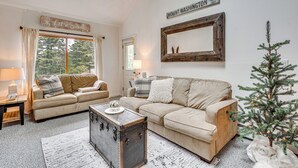 A cozy living room with two beige sofas, a wooden coffee table, a small Christmas tree, and a sign reading "Mount Washington". - Bartlett Condo: 1 Mi to Attitash Mountain Resort! (Bartlett)