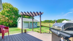 Une terrasse avec un barbecue et une pergola.