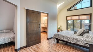 Un dormitorio con una cama grande, un armario y un baño visible a través de una puerta abierta.