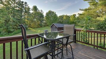 Enjoy a serene outdoor space with a deck, lush views, and a wooden railing.