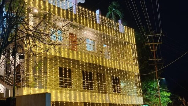 A multi-story building with string lights. - Haven Garden Homestay (Port Blair)