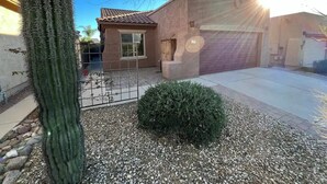 A residential area with a house, a large cactus, and a small bush. - Charming 3-bedroom house in Gold Canyon with 1 gigabit WiFi and amazing views (Gold Canyon)