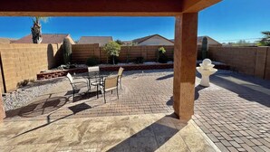 An outdoor patio with a covered area, a table with chairs, and a decorative fountain. - Charming 3-bedroom house in Gold Canyon with 1 gigabit WiFi and amazing views (Gold Canyon)