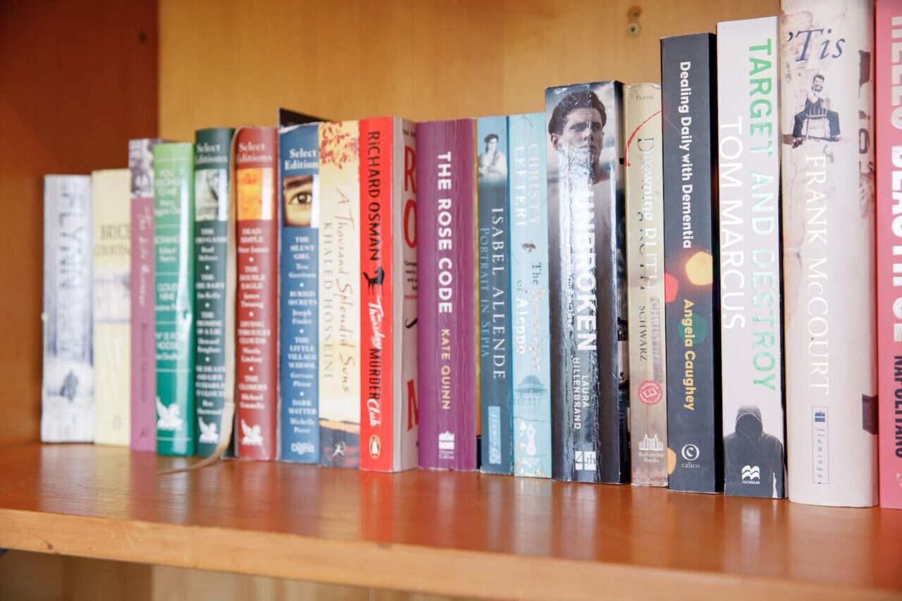 A bookshelf with various books, including titles like 'The Rose Code' and 'Target and Destroy'.