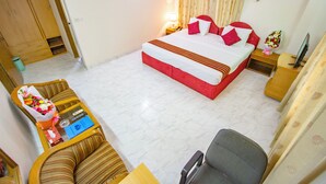 Ein Hotelzimmer mit Bett, Schreibtisch, Stuhl, Fernseher und Bad.