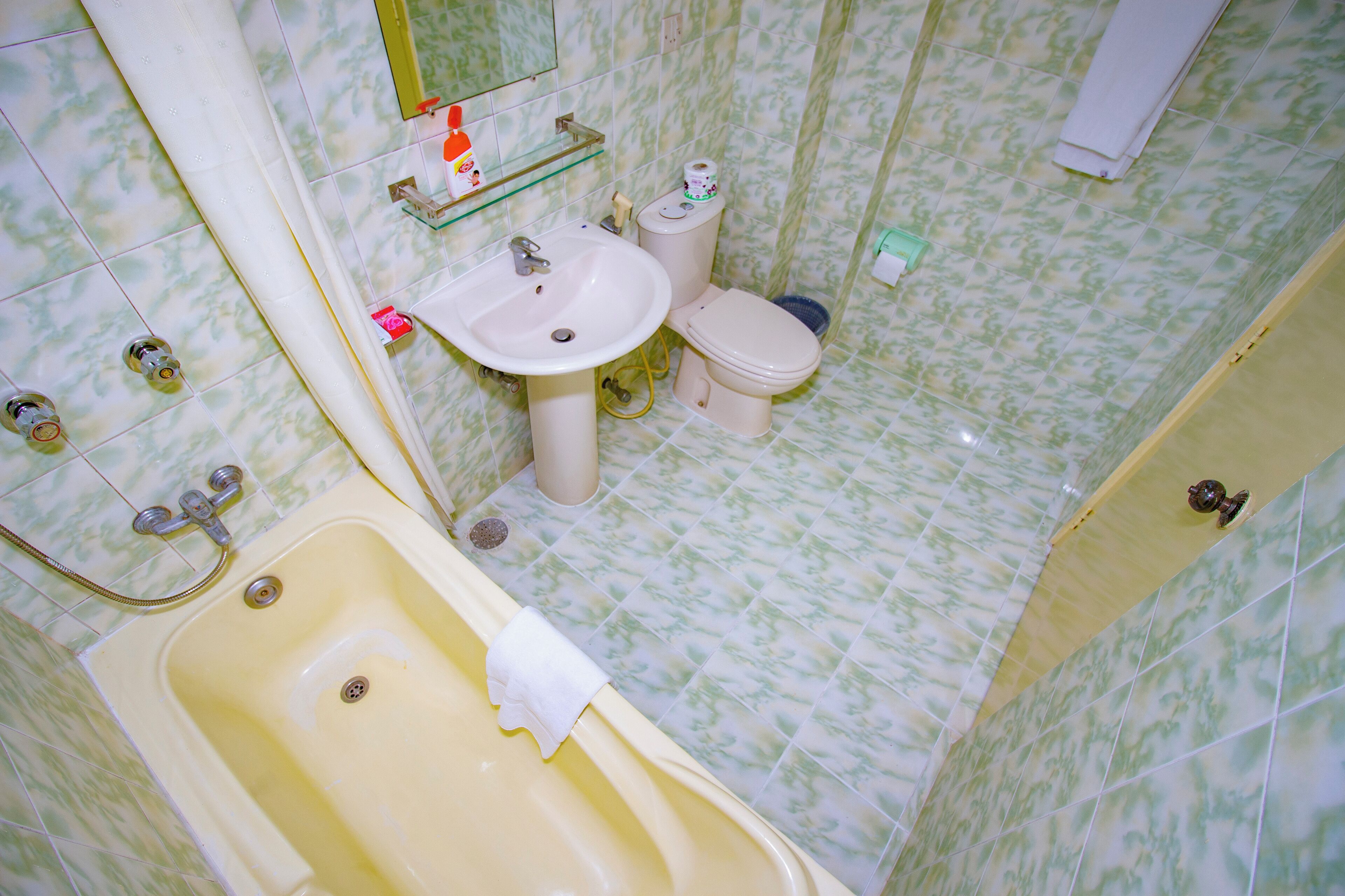 A bathroom with a bathtub, sink, toilet, and a mirror.