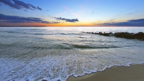 A beach with waves and a sunset. - Ferienwohnungen im Seepark Sellin (Sellin)