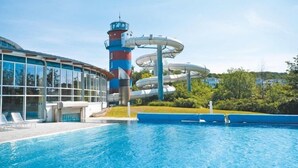 A swimming pool with a water slide and a lighthouse structure. - Ferienwohnungen im Seepark Sellin (Sellin)