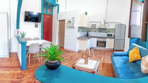 Un salon moderne comprenant un canapé, une table à manger et un coin cuisine.