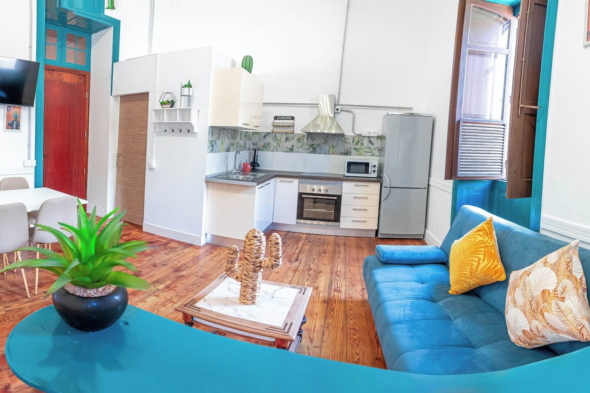 Uma sala moderna com sofá, mesa de jantar e área de cozinha.