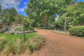 A dirt path leading through a park with trees and a rock formation. - The Willows-Award Winning New York Magazine Home! (Fredericksburg)
