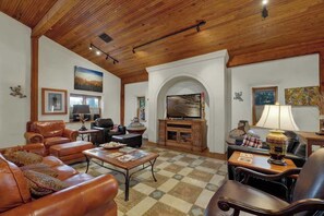 A spacious living room with leather sofas, a wooden ceiling, and a checkered floor. - The Willows-Award Winning New York Magazine Home! (Fredericksburg)