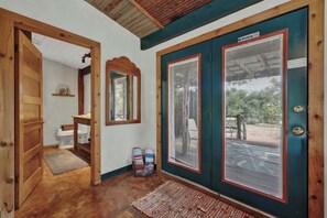 A wooden door with a 'No Smoking' sign, a view through the door, and a small rug on the floor.