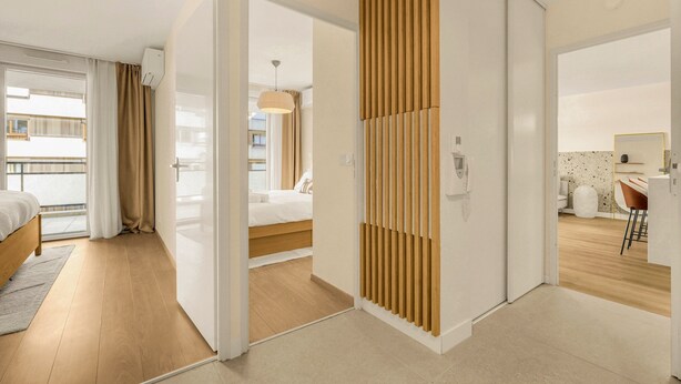 Une chambre d’hôtel moderne avec un plancher en bois, un lit, un bureau et une salle de bain.