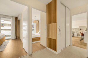 A modern hotel room with a wooden floor, a bed, a desk, and a bathroom. - Savana - apt à 10min du Capitole (Toulouse)
