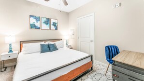 A bedroom with a bed, a ceiling fan, a desk, and a chair. - Fun Soco 1BR King Suite w Gympickleballlaundry (Austin)
