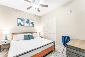 A bedroom with a bed, a ceiling fan, a desk, and a chair. - Fun Soco 1BR King Suite w Gympickleballlaundry (Austin)