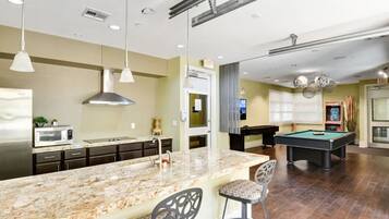 A modern kitchen with granite countertops, stainless steel appliances, and pendant lighting.
