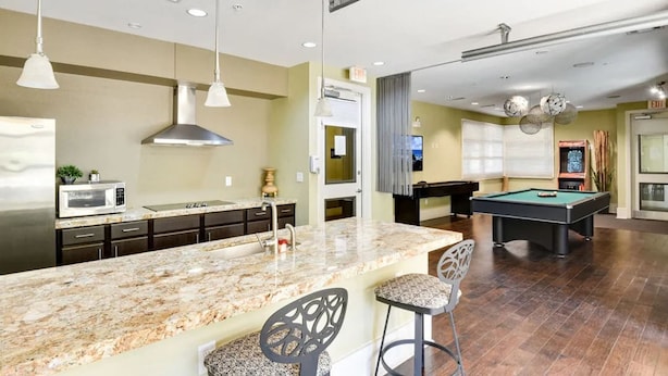A modern kitchen with granite countertops, a stainless steel refrigerator, and a built-in microwave. - Comfy Soco 1BR King Suite w Gympickleballlaundry (Austin)