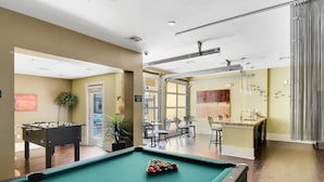 A pool table with balls, a foosball table, and a bar area with chairs and a sink. - Comfy Soco 1BR King Suite w Gympickleballlaundry (Austin)