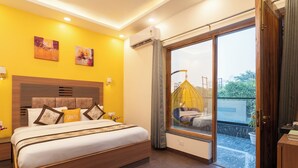 A modern bedroom with a large bed, a balcony with a hanging chair, and artwork on the walls. - Lime Tree Hotel & One BHK Serviced Apartment - Noida Sector 50 Metro (Noida)