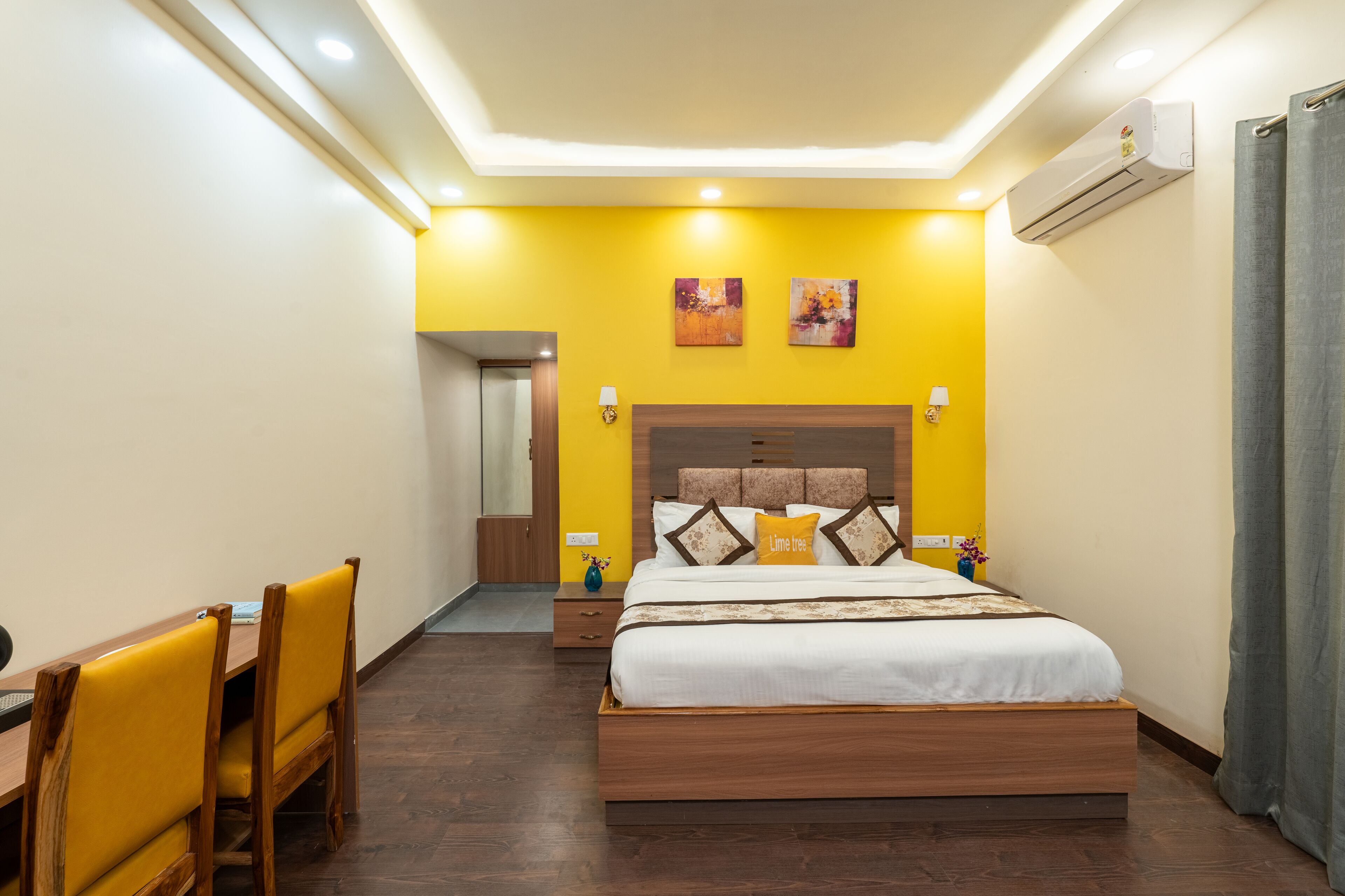 A bedroom with a bed, bedside tables, a desk, and chairs.