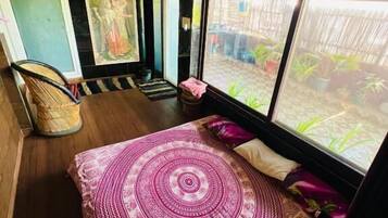 Una habitación con cama, una silla y una ventana.