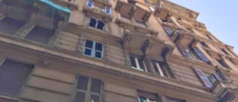 A multi-story building with balconies, large windows, and ornate architectural details.