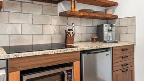 A kitchen with a granite countertop, stainless steel appliances, wooden cabinets, and a built-in oven.