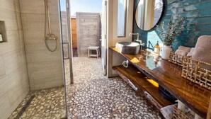 Ein Badezimmer mit Dusche, Waschbecken und Spiegel.