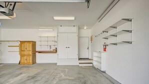 A spacious room with a concrete floor, white walls, a wooden cabinet, and built-in shelving. - Mountain Haven Retreat w/Hot Tub & Sauna STR-283 (Buena Vista)